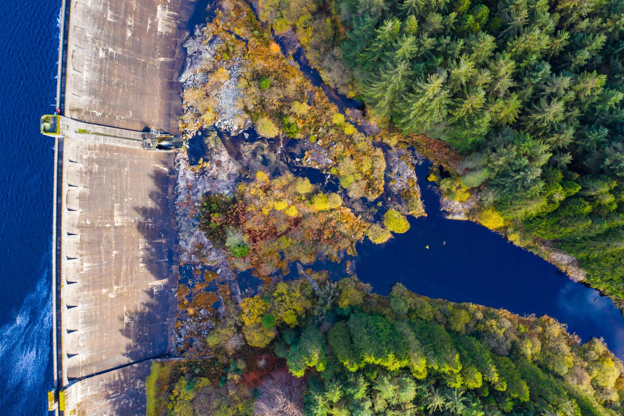 Drone view looking down on a dam and surrounding landscape