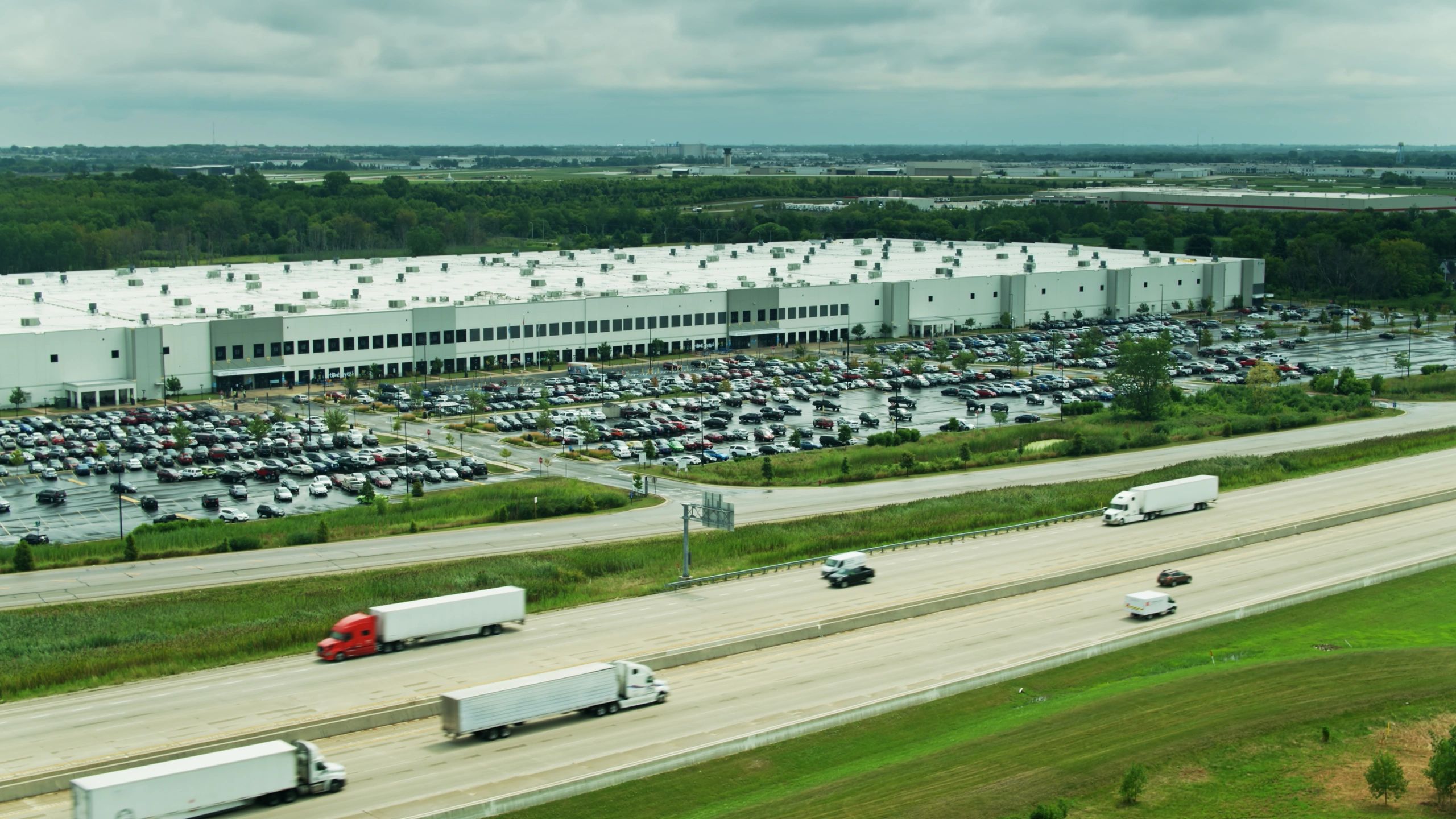Aerial view of a large industrial data center-style facility near a freeway
