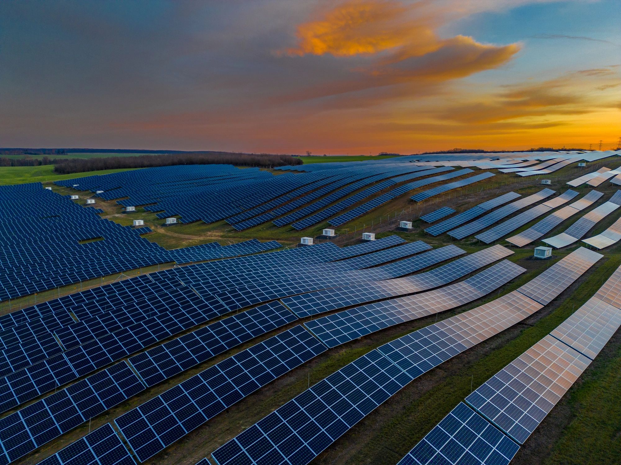 Aerial view of solar panels in rows at sunset