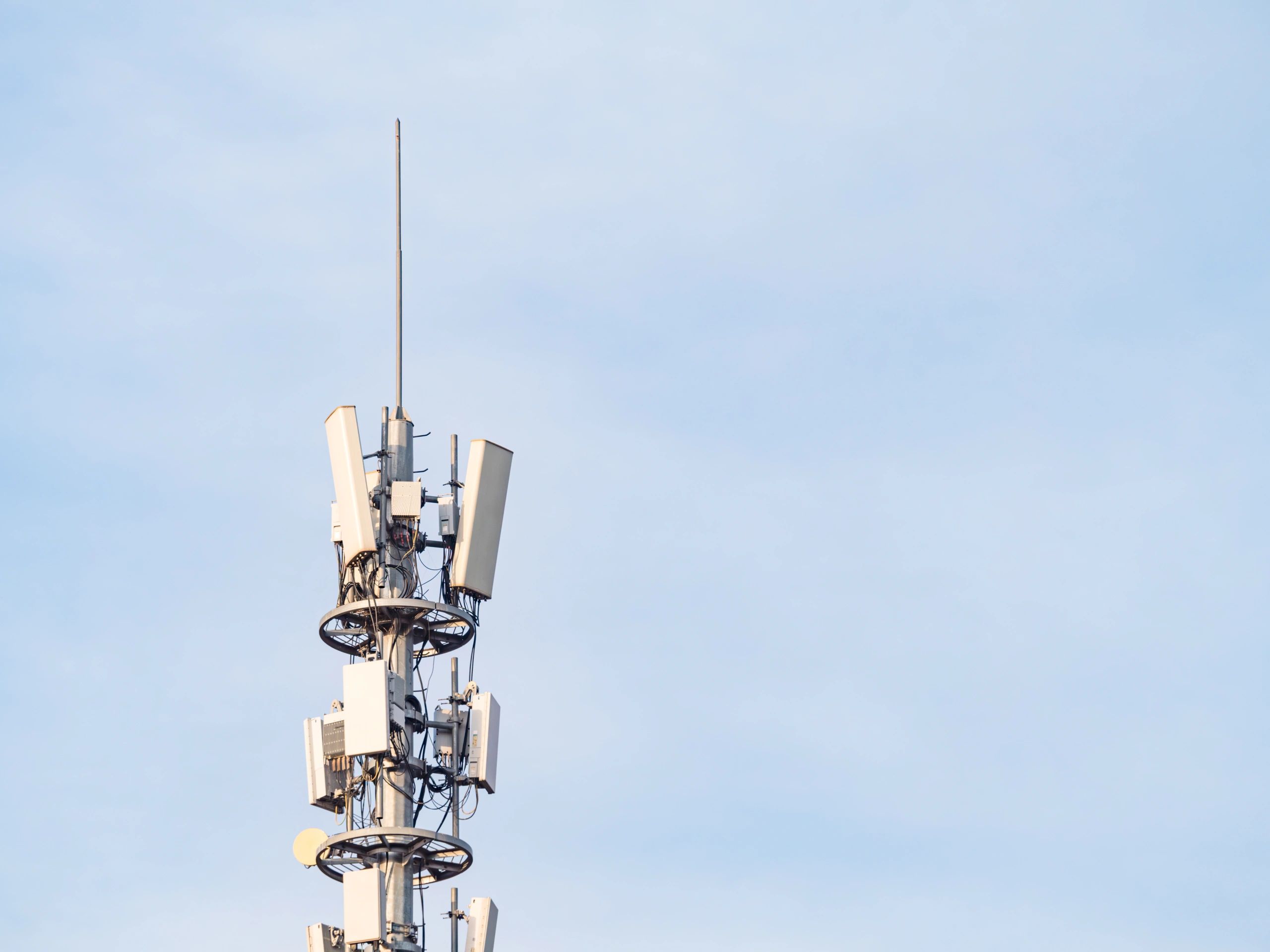 Telecommunications tower with multiple antennas against a blue sky