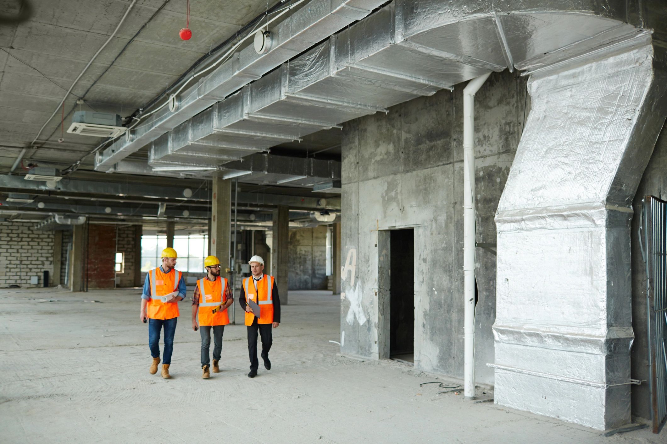 Field team walking through a construction site with safety gear